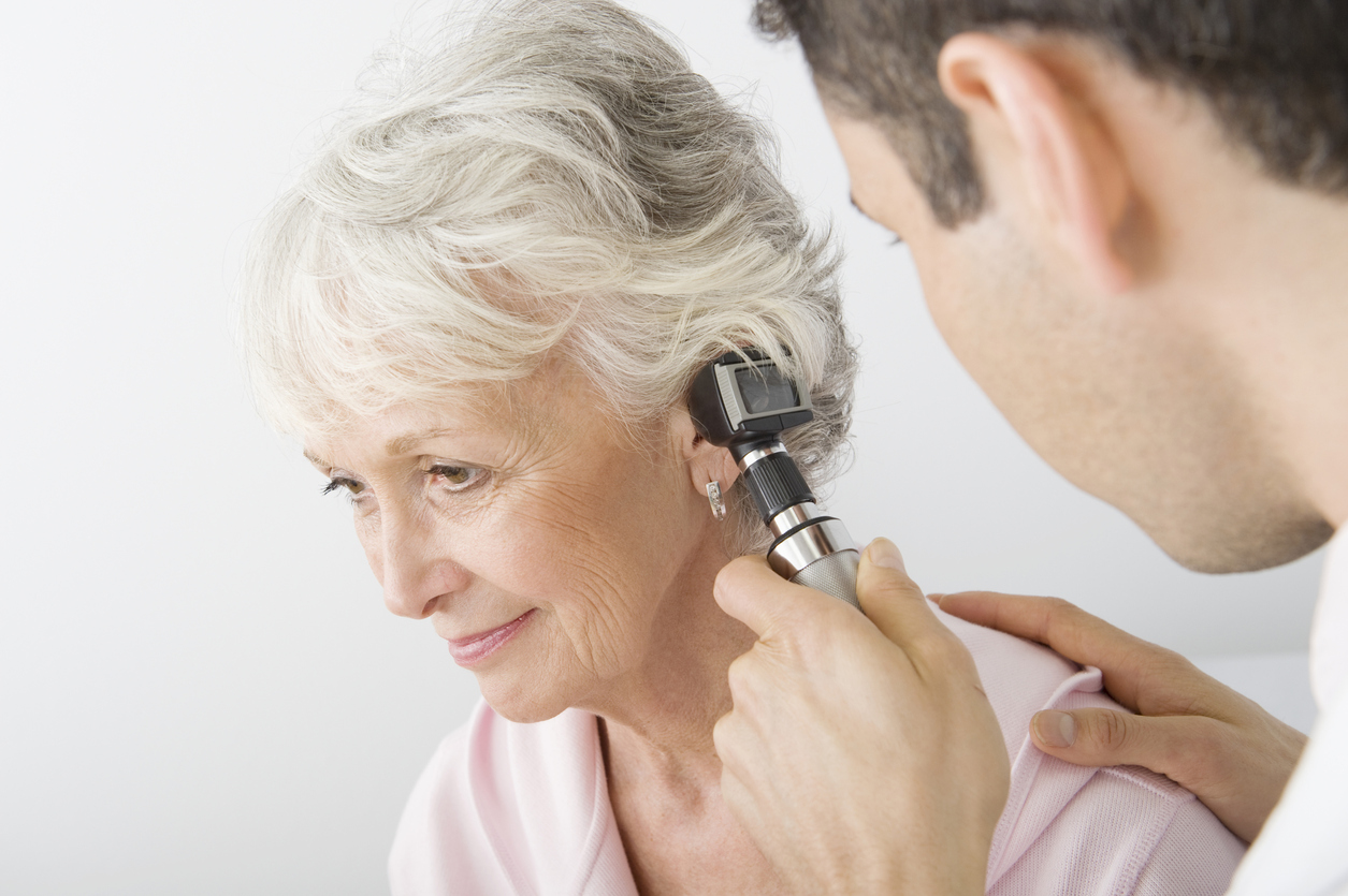 Doctor Examining Patient's Ear Using Otoscope In Clinic