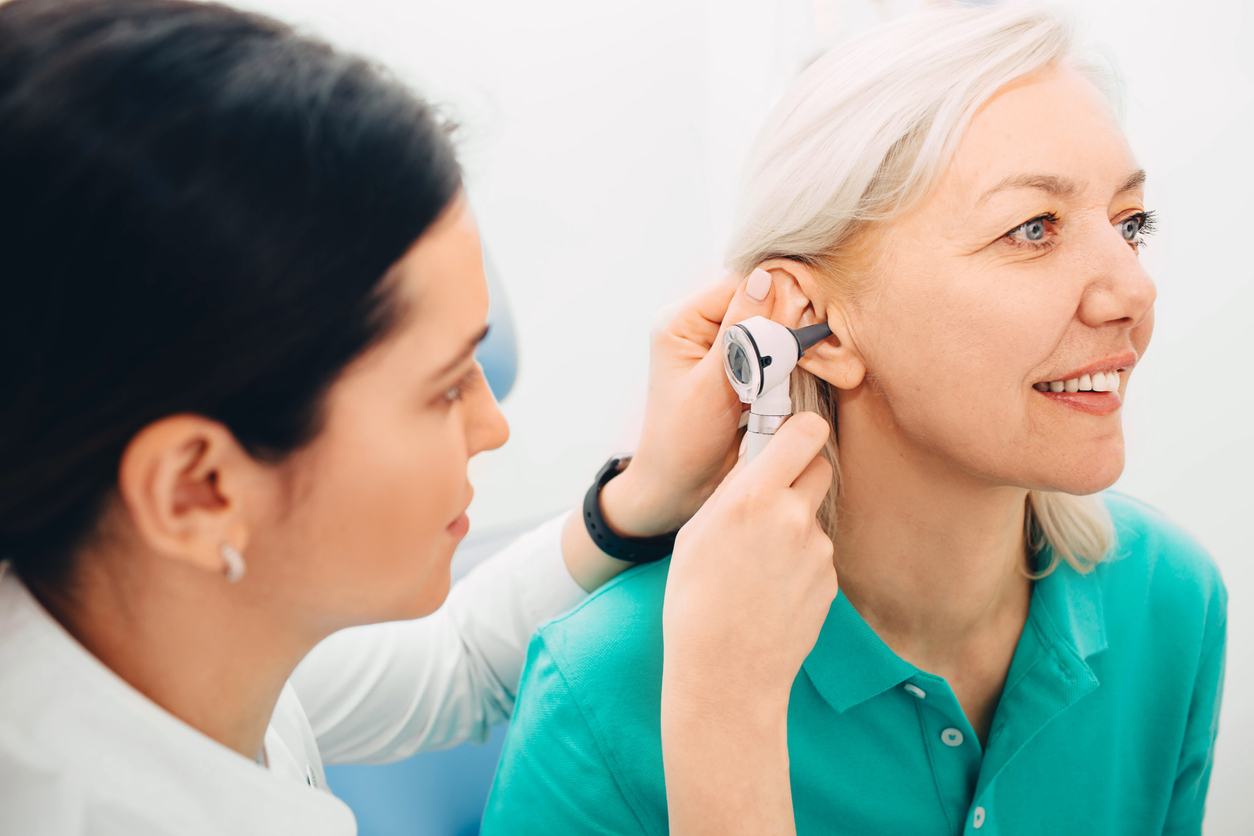 Mature woman getting ear exam at clinic